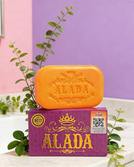 ALADA Instant Whitening Soap 160g with orange soap bar and purple box styled with green leaves in a clean beauty setting