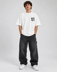 Model wearing a white duck oversized graphic T-shirt with baggy streetwear pants