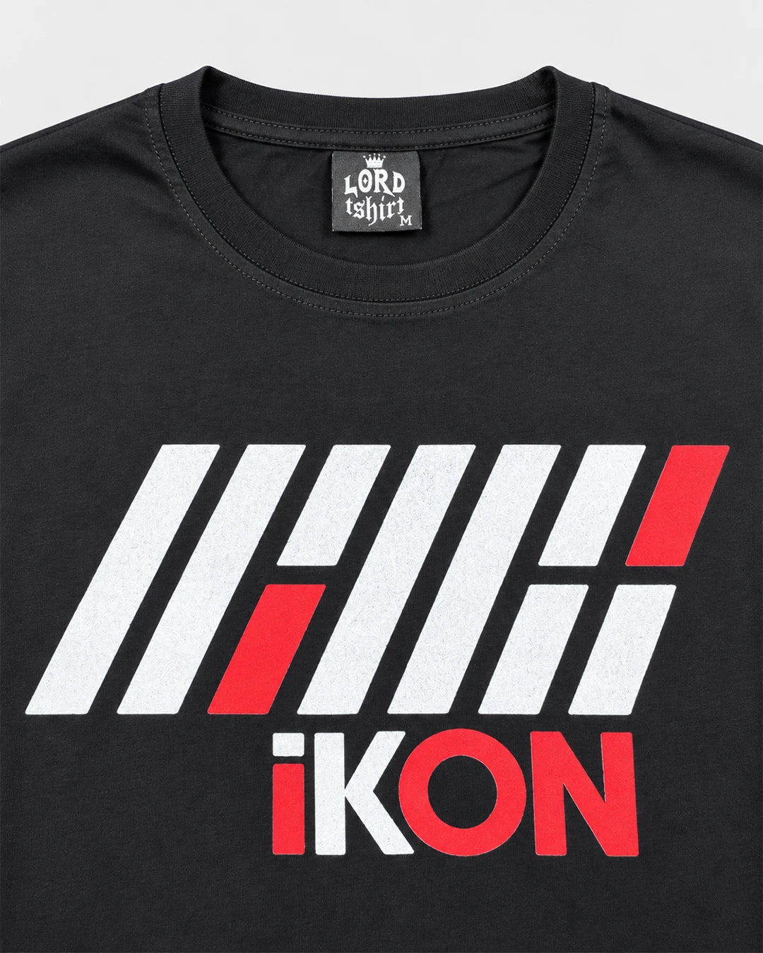 Close-up of iKON geometric logo and red and white lettering printed on black fabric