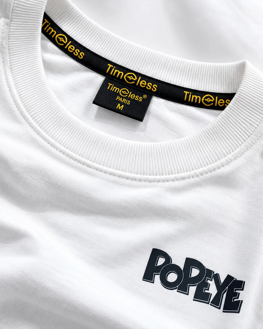 Close-up detail of Popeye graphic and fabric on white oversized T-shirt